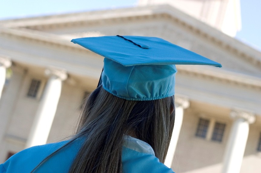 Dauphin County reentry program graduate in cap and gown, viewed from behind, looking at a government building