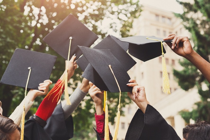 Cambria County reentry program graduates throwing caps into the air in celebration.