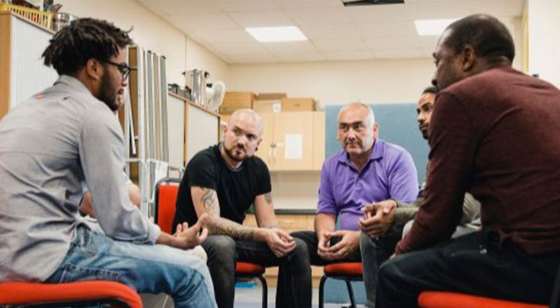 Participants attending a group session in a forensic residential treatment program
